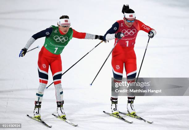 Marit Bjoergen of Norway and Maiken Caspersen Falla of Norway handover during the Cross Country Ladies' Team Sprint Free Final on day 12 of the...