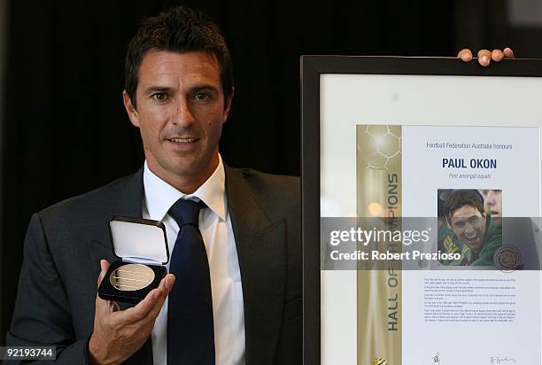 Paul Okon poses with his medallion for induction into the Hall of Champions at the Football Hall of Fame Induction Luncheon at Zinc Restaurant on...