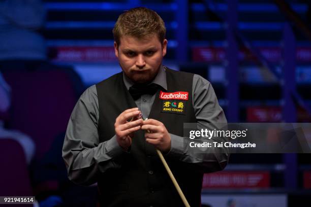 Michael White of Wales chalks the cue during his first round match against Judd Trump of England on day two of 2018 Ladbrokes World Grand Prix at...