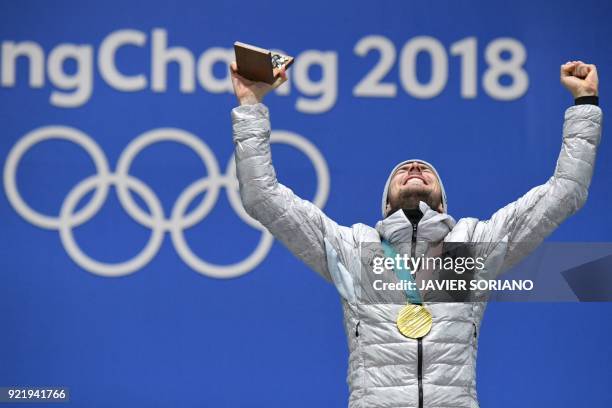 Germany's gold medallist Johannes Rydzek poses on the podium during the medal ceremony for the nordic combined Individual Gundersen LH/10km at the...