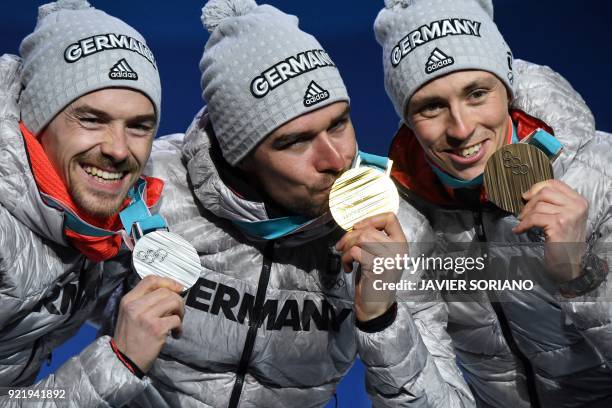 Germany's silver medallist Fabian Riessle, Germany's gold medallist Johannes Rydzek and Germany's bronze medallist Eric Frenzel pose on the podium...