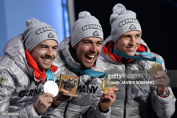 Germany's silver medallist Fabian Riessle, Germany's gold medallist Johannes Rydzek and Germany's bronze medallist Eric Frenzel pose on the podium...