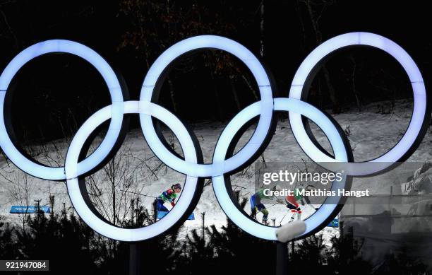 Stina Nilsson of Sweden, Maiken Caspersen Falla of Norway and Jessica Diggins of the United States compete as they pass the Olympic Rings during the...