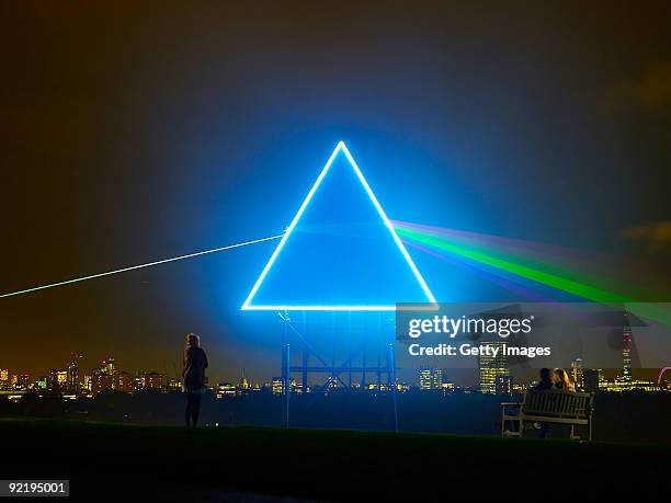 Passers-by watch as Sky Arts pays tribute to Pink Floyd's iconic "Dark Side Of The Moon" album cover, on Primrose Hill, October 21, 2009 in London....