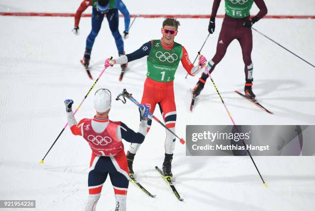 Johannes Hoesflat of Norway celebrates as he crosses the finish line to win gold with team mate Martin Johnsrud Sundby of Norway during the Cross...