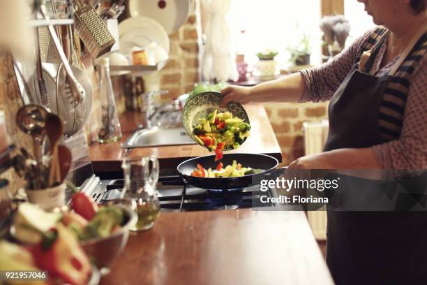 cooking vegetables, step five, using pan - holding saucepan stock pictures, royalty-free photos & images