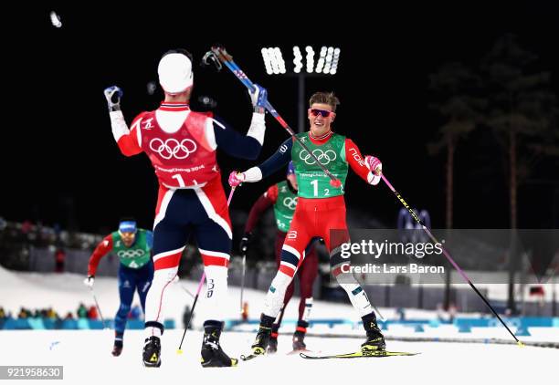Johannes Hoesflat of Norway celebrates as he crosses the finish line to win gold with team mate Martin Johnsrud Sundby of Norway during the Cross...