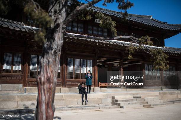 Women check their phones as they visit Deoksugung Palace on February 21, 2018 in Seoul, South Korea. With tourists visiting from around the world,...