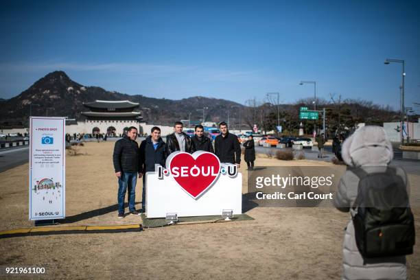 Tourists pose for a photograph with Gyeongbokgung Palace and Bugaksan Mountain in the background on February 21, 2018 in Seoul, South Korea. With...