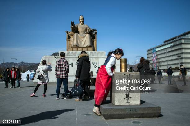 Tourists view a statue of King Sejong as they visit Gwanghwamun Square on February 21, 2018 in Seoul, South Korea. With tourists visiting from around...