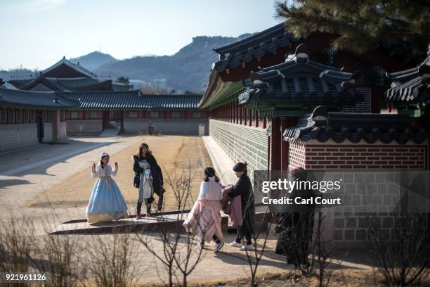 Tourists, some wearing traditional Korean Hanbok dresses, visit Gyeongbokgung Palace on February 21, 2018 in Seoul, South Korea. With tourists...