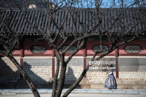 Woman wearing a traditional Korean Hanbok dress takes a selfie photograph as she visits Gyeongbokgung Palace on February 21, 2018 in Seoul, South...