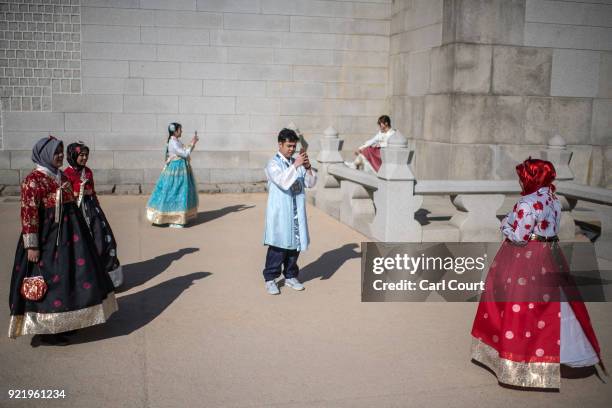 Tourists wearing traditional Korean Hanbok dresses pose for photographs near Gyeongbokgung Palace on February 21, 2018 in Seoul, South Korea. With...