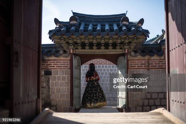 Woman wearing a traditional Korean Hanbok dress poses for a photograph in a doorway as she visits Gyeongbokgung Palace on February 21, 2018 in Seoul,...