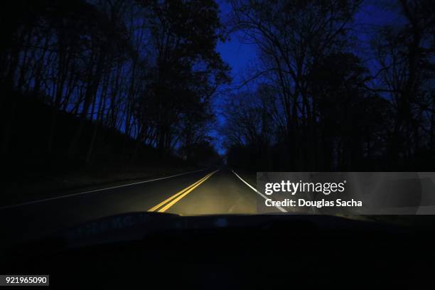 dashboard view of a moving car on spooky night - windschutzscheibe stock-fotos und bilder