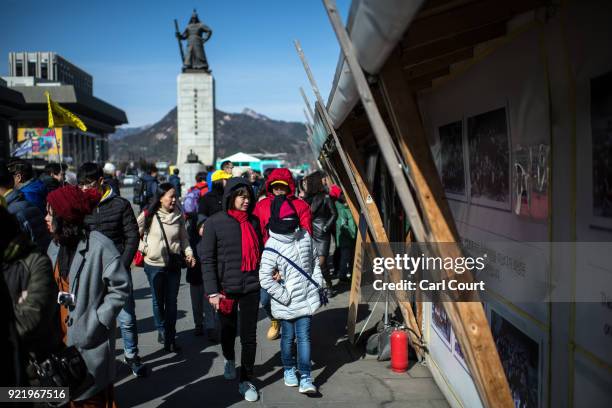 Tourists walk past a memorial to the victims of the MV Sewol which sank in 2014 killing 304 people, in Gwanghwamun Square on February 21, 2018 in...