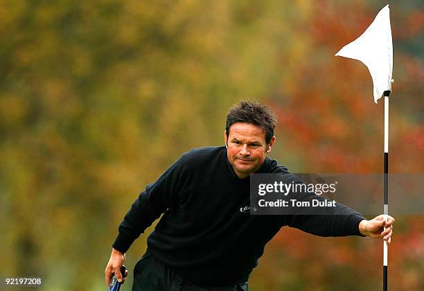 Neil Cheetham of Dore & Totley removes a flag from the 3rd hole during the Srixon PGA Playoff at Little Aston Golf Club on October 22, 2009 in Sutton...