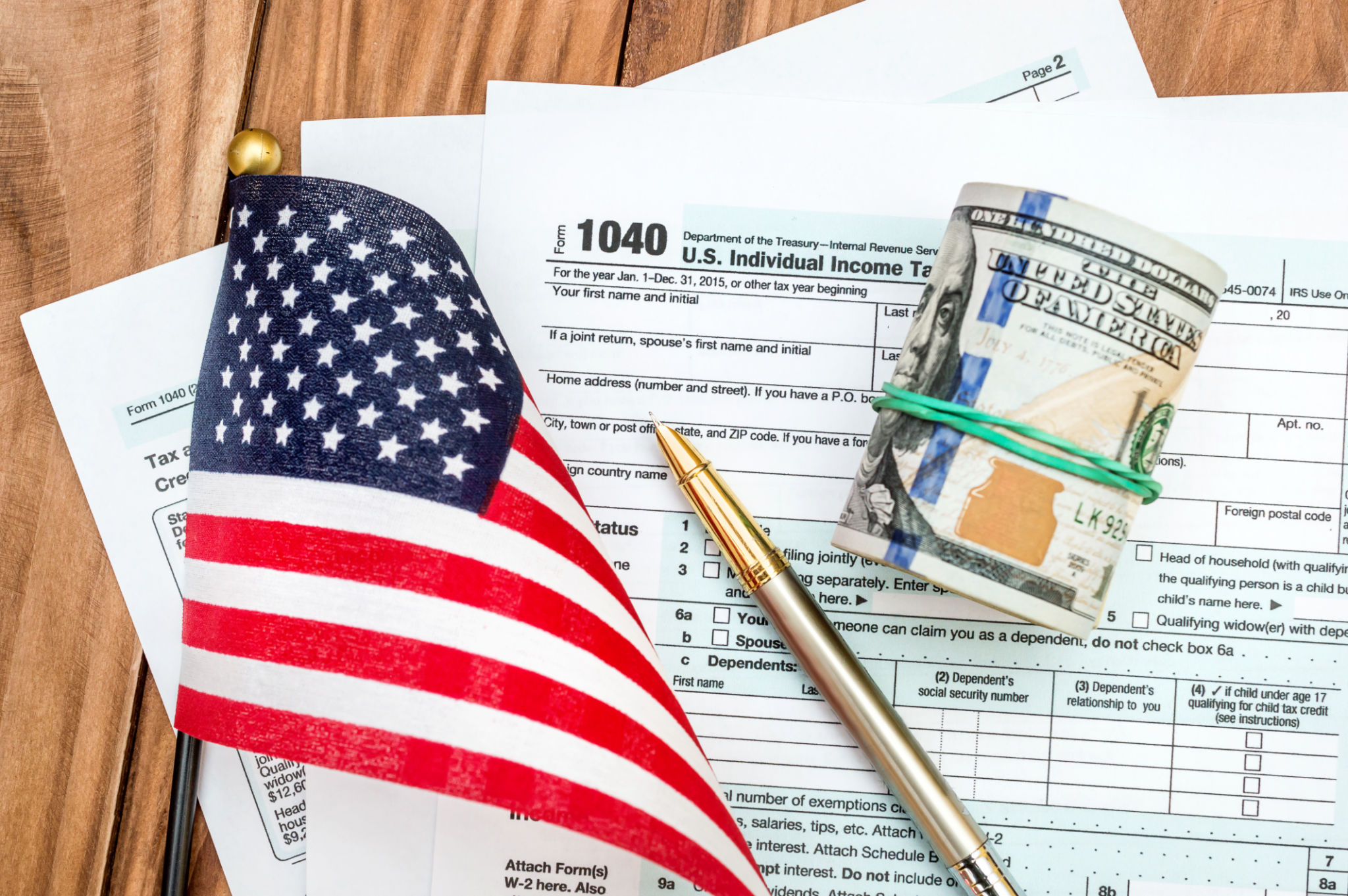 Tac concept. Tax form with small american flag and dollar bills on the table. Tac concept. Tax form with small american flag and dollar bills on the table.