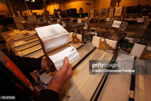 Workers sort through mail at one of TNT Post's sorting centres on October 22, 2009 in Ashton, England. TNT Post is one of the many British businesses...