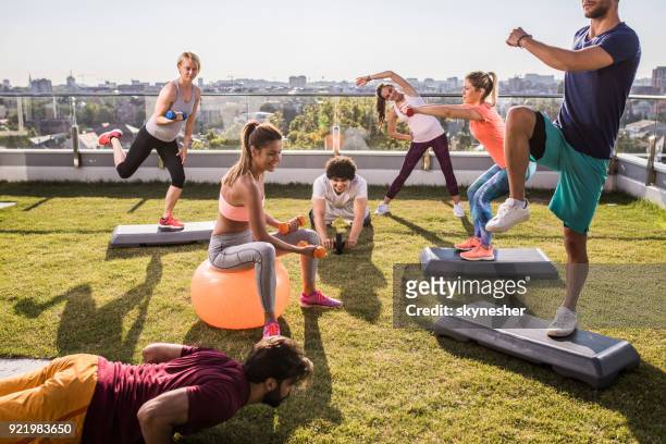 group of young athletes having sports training on a penthouse terrace. - yoga ball outside stock pictures, royalty-free photos & images