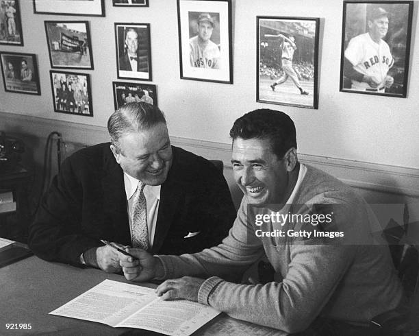 Baseball legend Ted Williams of the Boston Red Sox signs a baseball contract as Boston Manager Joe Cronin looks on in 1958. The 83-year-old Williams,...