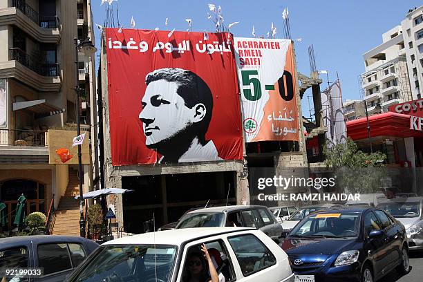 Cars drive past an electoral campaign billboard for Lebanese candidate Nadim Gemayel, son of slain president-elect Bashir Gemayel, in Beirut's...