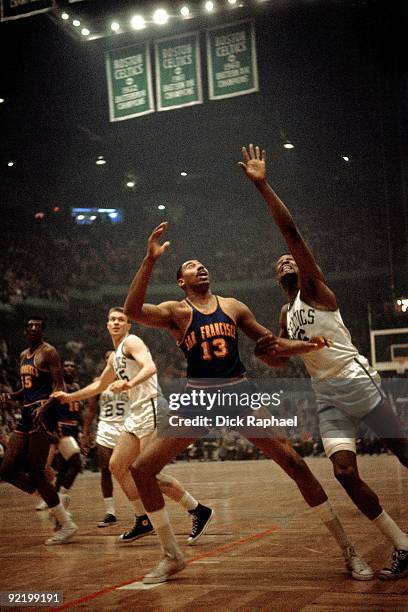 Wilt Chamberlain of the San Francisco Warriors posts up against Bill Russell of the Boston Celtics during a game played in 1964 at the Boston Garden...