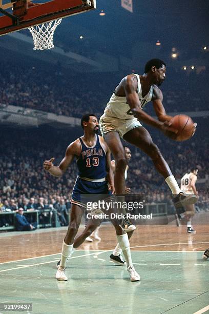 Bill Russell of the Boston Celtics rebounds against Wilt Chamberlain of the Philadelphia 76ers during a game played in 1968 at the Boston Garden in...