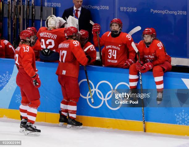 Russian athlete Yevgenia Dyupina reacts with team mates Anna Shokhina and Svetlana Tkachyova after the Women's Ice Hockey Bronze Medal game on day...