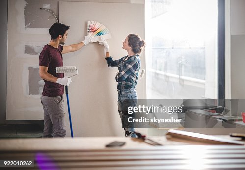 Junges Paar, die Wahl der richtigen Farbe für ihre Wand Renovierung Wohnung. Junges Paar, die Wahl der richtigen Farbe für ihre Wand Renovierung Wohnung.
