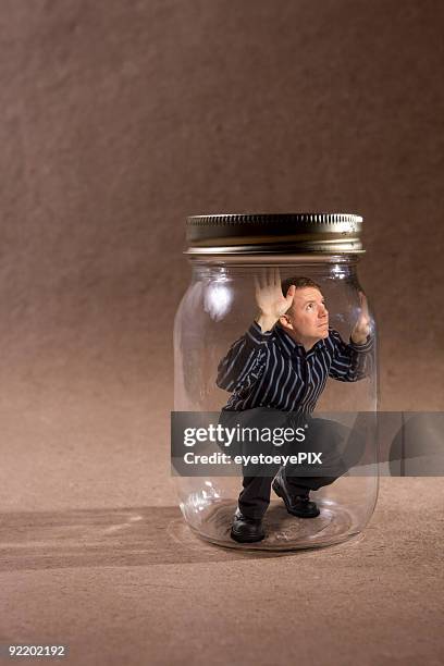 man trapped in mason jar looking out (concept series) - stuck stock pictures, royalty-free photos & images
