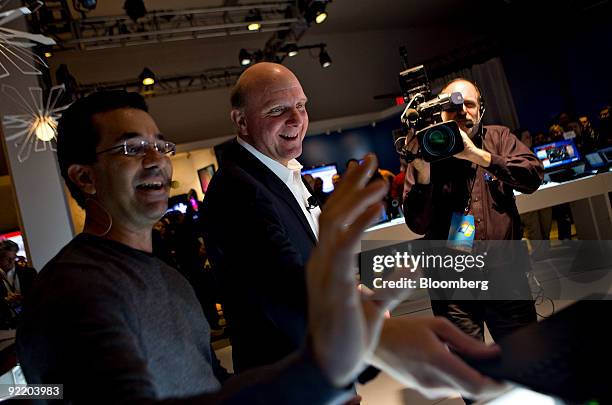 Steve Ballmer, chief executive officer of Microsoft Corp., center, looks over new computers running Windows 7 with Michael Angiulo, general manager...