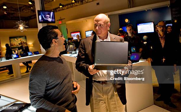Steve Ballmer, chief executive officer of Microsoft Corp., right, looks over new computers running Windows 7 with Michael Angiulo, general manager of...