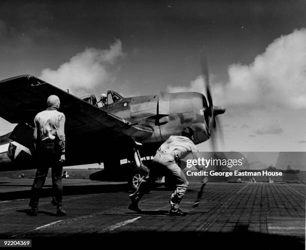 Lieutenant John M. Clark waves the take-off flag for a Grumman F6F-3 Hellcat of Fighting Squadron Sixteen on the deck of the aircraft carrier USS...