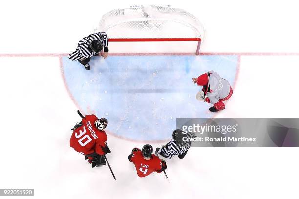 Ben Scrivens of Canada inspects an issue with the ice with officials before the start of the second period against Finland during the Men's Play-offs...