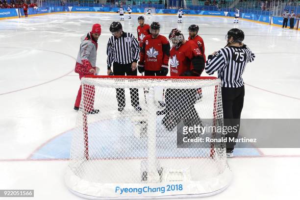 Ben Scrivens of Canada inspects an issue with the ice with officials before the start of the second period against Finland during the Men's Play-offs...
