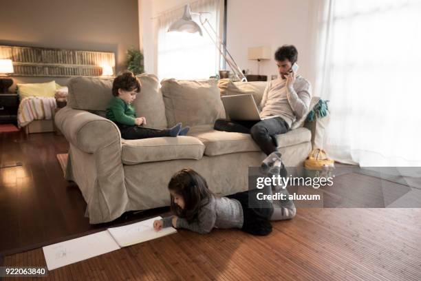 father working at home with laptop computer - oblivious stock pictures, royalty-free photos & images