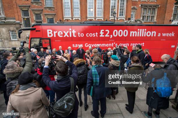 Members of the media gather around a bus with the campaign motto: "Brexit to cost £2,000 million a week says government's own report. Is it worth...