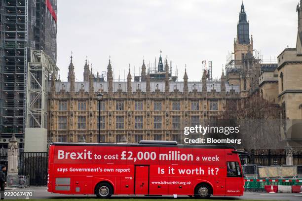 Bus with the campaign motto: "Brexit to cost £2,000 million a week says government's own report. Is it worth it?" passes the Houses of Parliament in...