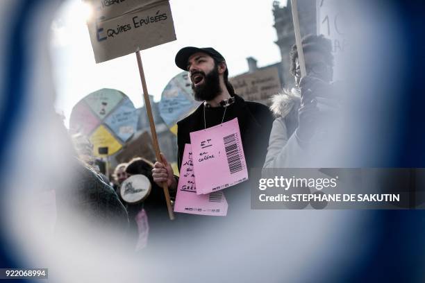 Man holds placards and chants slogans during a gather called by the French Office for Refugees and Stateless Persons , to protest against the...