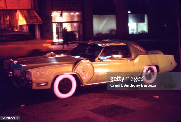 View of a heavily customized 1973 Cadillac Eldorado 'pimpmobile' parked on a street in Harlem, New York, New York, 1970s.