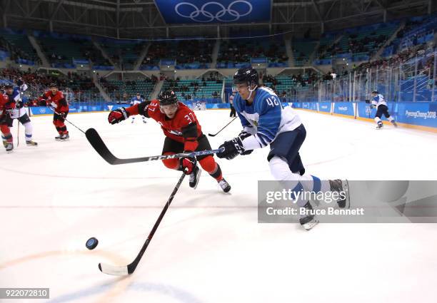 Miro Heiskanen of Finland competes for the puck with Mat Robinson of Canada in the second period during the Men's Play-offs Quarterfinals on day...
