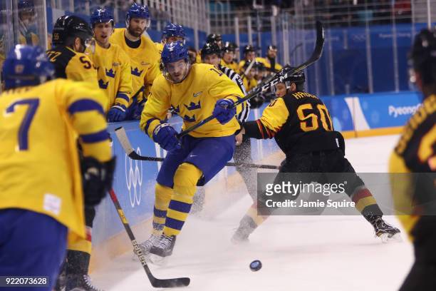 Dennis Everberg of Sweden controls the puck against Patrick Hager of Germany during the Men's Play-offs Quarterfinals game on day twelve of the...