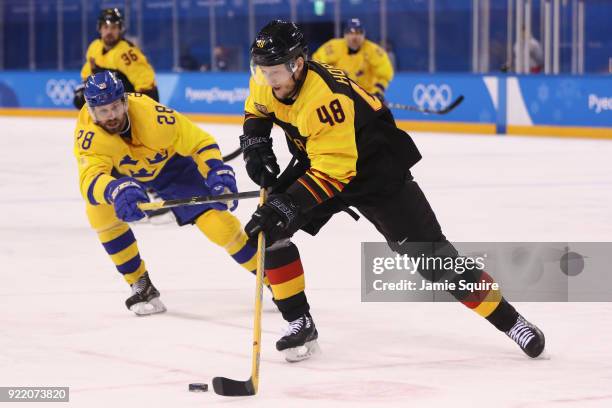 Frank Hordler of Germany controls the puck against Dick Axelsson of Sweden during the Men's Play-offs Quarterfinals game on day twelve of the...