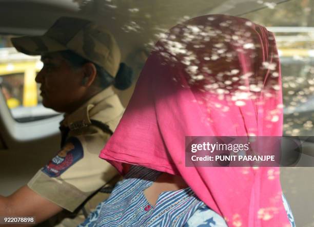 An Indian woman accused in the Punjab National Bank fraud case is escorted after her appearance in the special CBI court in Mumbai on February 21,...