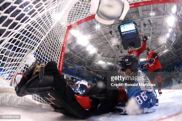 Veli-Matti Savinainen of Finland collides with Ben Scrivens of Canada in the second period during the Men's Play-offs Quarterfinals on day twelve of...