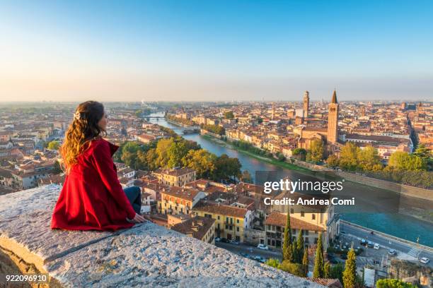 a young woman admires the view of verona old town from castel san pietro - italy city stock-fotos und bilder