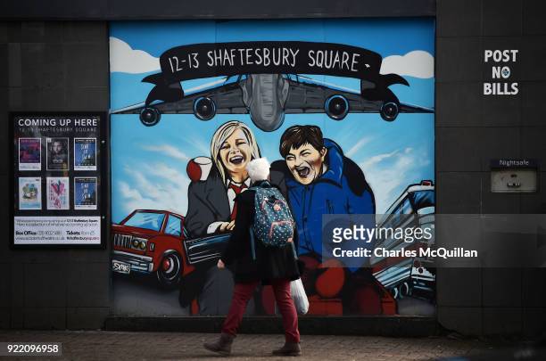 Woman looks at a mural depicting Sinn Fein vice president Michelle O'Neill and DUP leader Arlene Foster as the unlikely bedfellow characters from the...