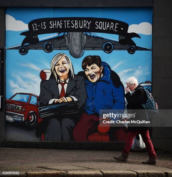 Woman walks past a mural depicting Sinn Fein vice president Michelle O'Neill and DUP leader Arlene Foster as the unlikely bedfellow characters from...