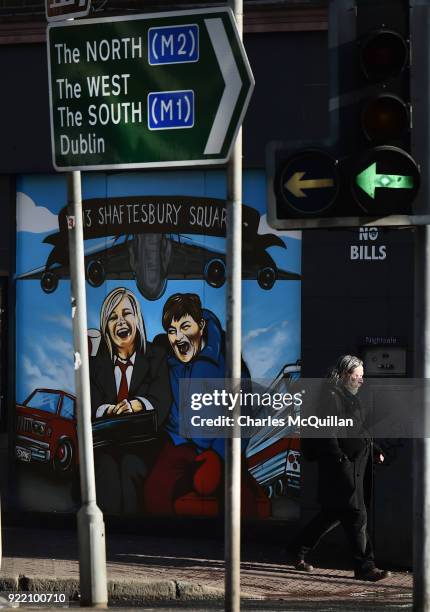 Man walks past a mural depicting Sinn Fein vice president Michelle O'Neill and DUP leader Arlene Foster as the unlikely bedfellow characters from the...